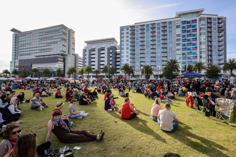 Festivalgoers spread across the lawn at Luminary Green Park