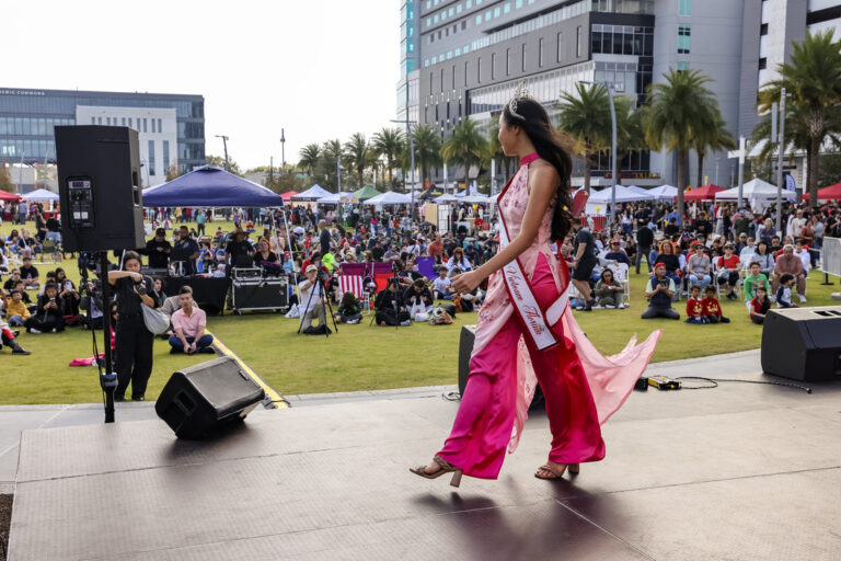 A performer crosses the Celebrate Lunar main stage in front of the festival crowd