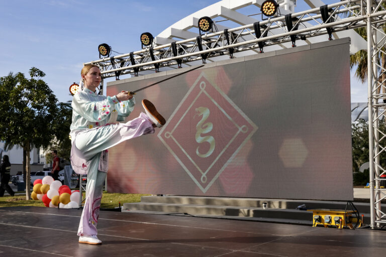 A martial artist performing a sword form on the Celebrate Lunar main stage