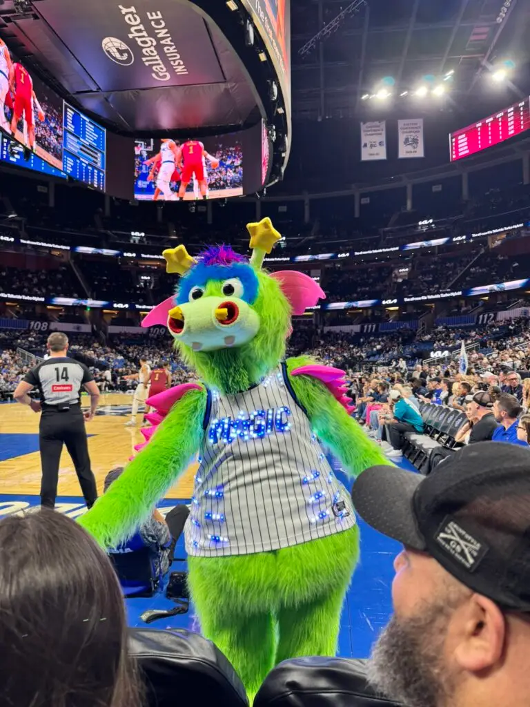 Stuff the Magic Dragon, the Orlando Magic's green mascot, in a light-up pinstripe jersey greets courtside fans at Kia Center